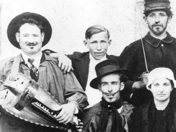 Un joueur de vielle dans une photo de famille en noir blanc, début du siècle dernier