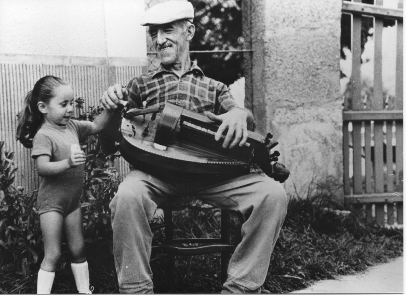 Un joueur de vielle en extérieur, photo en noir et blanc, après-guerre
